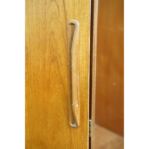 649 - G Plan three door wardrobe, two concertina doors and one further door, maker's label inside, hanging... 