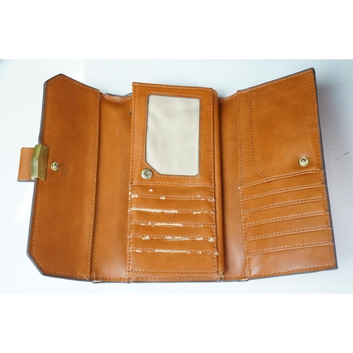 369 - A collection of over forty leather wallets and purses of various sizes and colours.