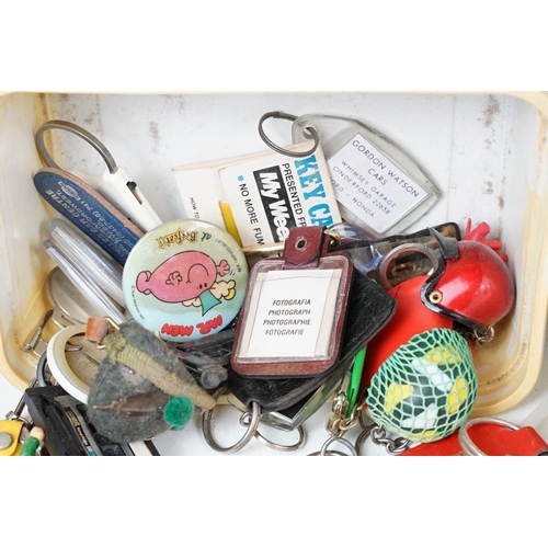 384 - A collection of vintage buttons badges and keyrings to include many advertising examples.