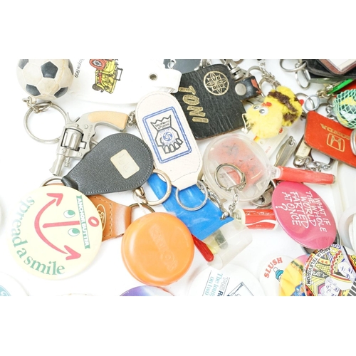 384 - A collection of vintage buttons badges and keyrings to include many advertising examples.