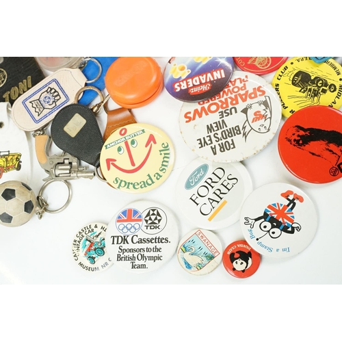 384 - A collection of vintage buttons badges and keyrings to include many advertising examples.
