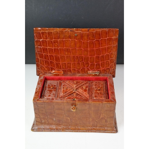 393 - An antique Alligator skin jewellery box with fitted segmented interior and complete with key.