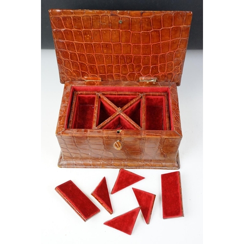 393 - An antique Alligator skin jewellery box with fitted segmented interior and complete with key.