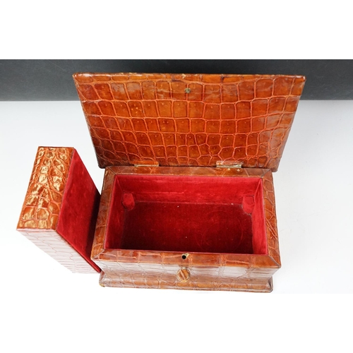 393 - An antique Alligator skin jewellery box with fitted segmented interior and complete with key.