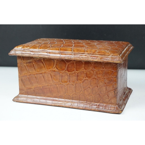 393 - An antique Alligator skin jewellery box with fitted segmented interior and complete with key.