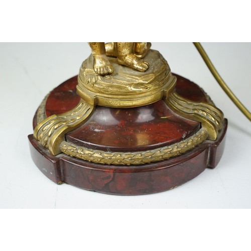 185 - Gilt metal table lamp modelled as two putto, with a red marble base with gilt metal mounts (detached... 