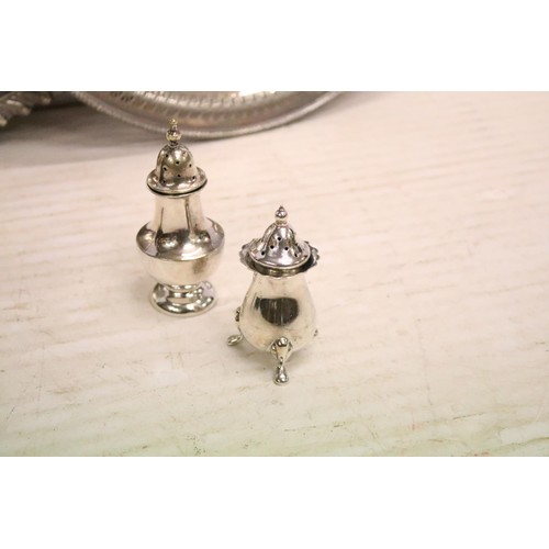 511 - Silver plated twin-handled tray, 61cm long, a silver plated circular tray, two silver plated pepper ... 