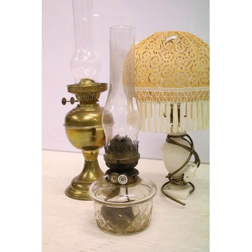 469 - Two 19th Century Victorian oil lamps having milk glass shades together with a carved stone lamp base... 