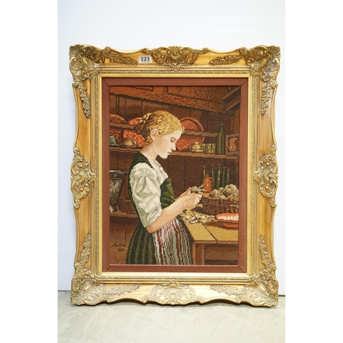 223 - Tapestry panel depicting a young woman in a kitchen, bearing signature and date 1885, 55 x 40cm, gil... 