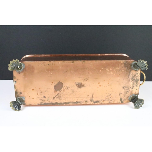 107 - Copper planter with rolled rim and brass lion mask drop ring handles, raised on brass lion paw feet,... 