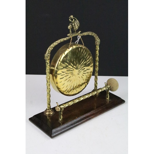 118 - 20th century brass dinner gong raised on an oak base, complete with striker, approx 28cm tall