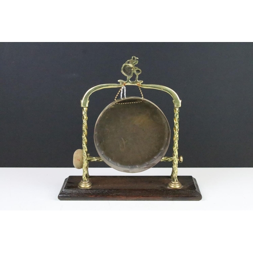 118 - 20th century brass dinner gong raised on an oak base, complete with striker, approx 28cm tall