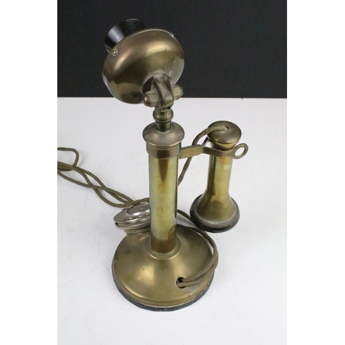 181 - Early 20th Century chamberstick telephone with brass body. Measures 31cm tall.