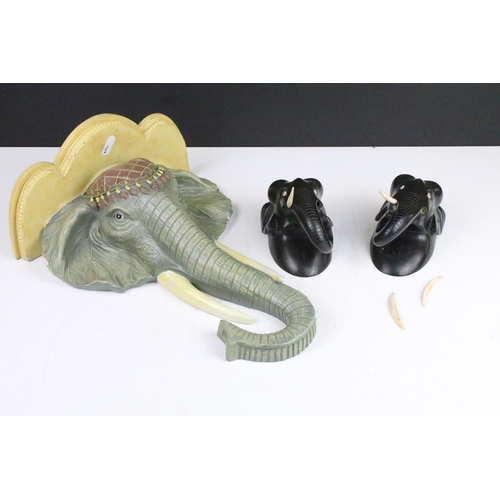 182 - Cast resign wall sconce shelf in the form of an elephant together with two carved wood elephant wall... 