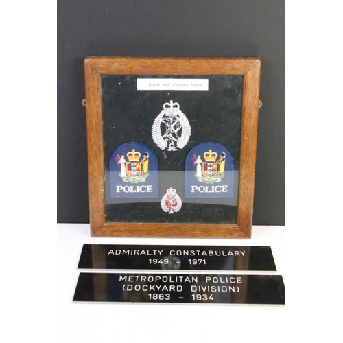 187 - A framed group of Royal New Zealand Police badges together with two police signs.