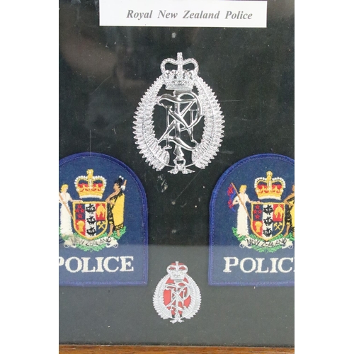 187 - A framed group of Royal New Zealand Police badges together with two police signs.