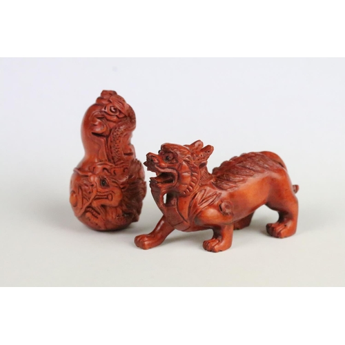 193 - Two carved wooden netsuke figurines including a fu dog and a gourd shaped toggle with dragon detaili... 