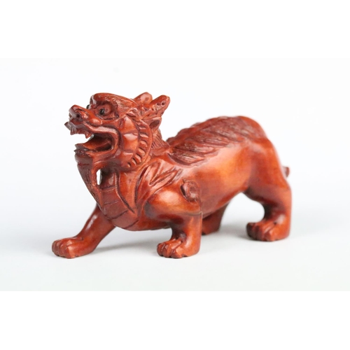 193 - Two carved wooden netsuke figurines including a fu dog and a gourd shaped toggle with dragon detaili... 