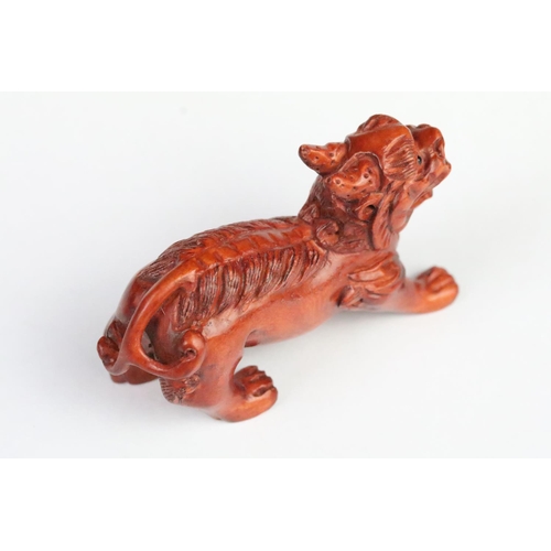 193 - Two carved wooden netsuke figurines including a fu dog and a gourd shaped toggle with dragon detaili... 