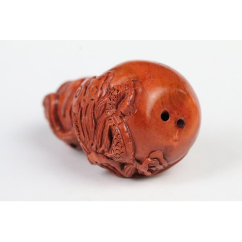 193 - Two carved wooden netsuke figurines including a fu dog and a gourd shaped toggle with dragon detaili... 