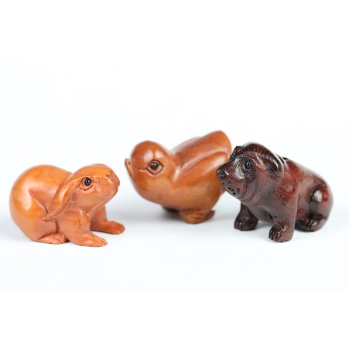 202 - Three Chinese carved wooden animal figurines to include a rabbit, bulldog and chick. Largest measure... 