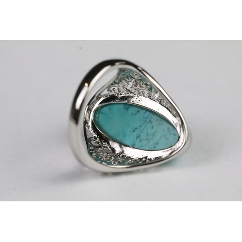 234 - Silver and turquoise dress ring being set with an oval cabochon to centre with pierced shoulders. Ma... 