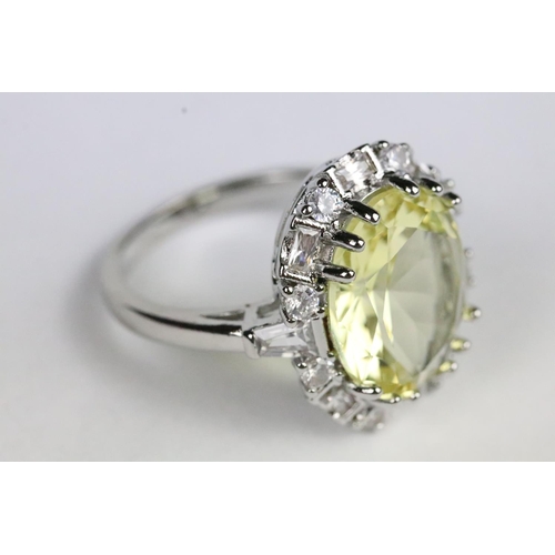 254 - Silver and yellow stone dress ring having a halo of white accent stones. Band marked s925. Size P.5.