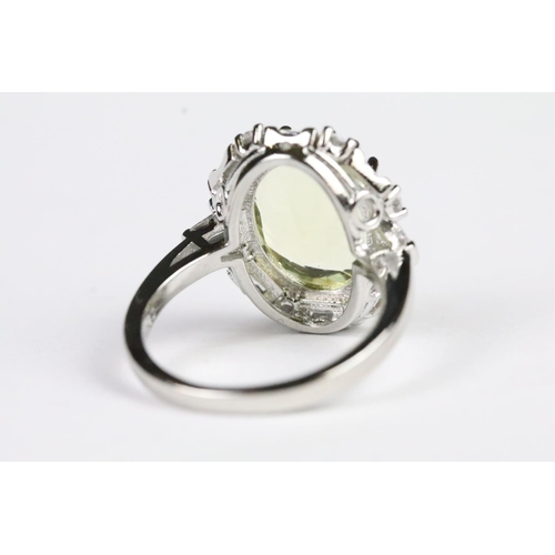 254 - Silver and yellow stone dress ring having a halo of white accent stones. Band marked s925. Size P.5.