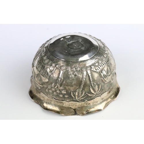 266 - Indian white metal Lucknow bowl having a repousse village scene to the sides with fanned rim. Measur... 