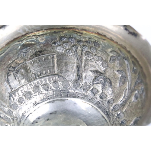 266 - Indian white metal Lucknow bowl having a repousse village scene to the sides with fanned rim. Measur... 