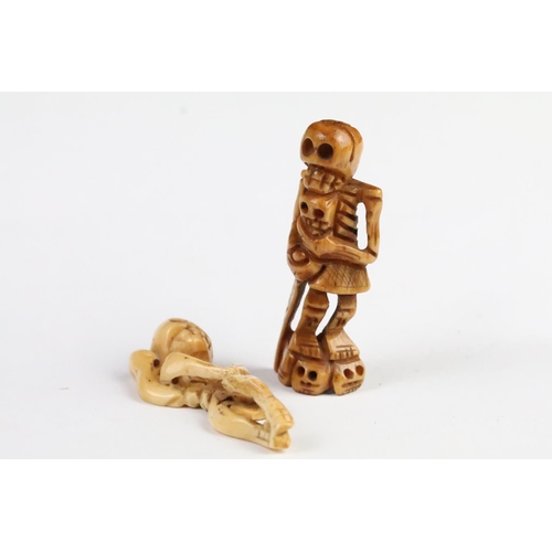 274 - Two carved bone netsuke in the form of skeletons. Measures 6cm and 5.5cm.