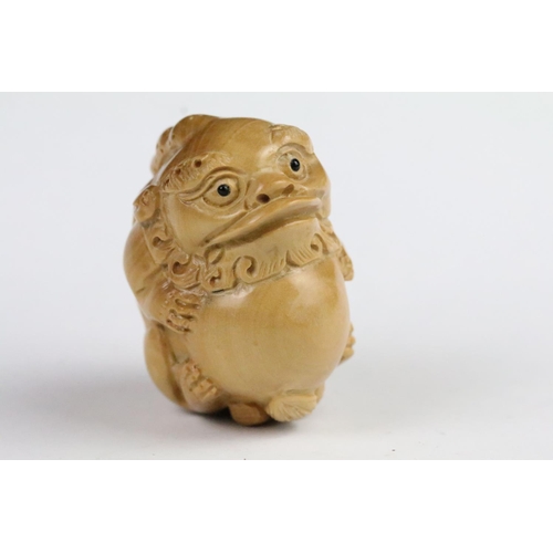 276 - Two carved wooden netsuke in the form of a tortoise and a mythical beast. Measures 5cm and 6.5cm.