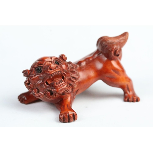 283 - Two carved wooden netsuke to include a pig and a fu dog. Measures 5cm and 6cm.