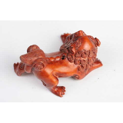 283 - Two carved wooden netsuke to include a pig and a fu dog. Measures 5cm and 6cm.