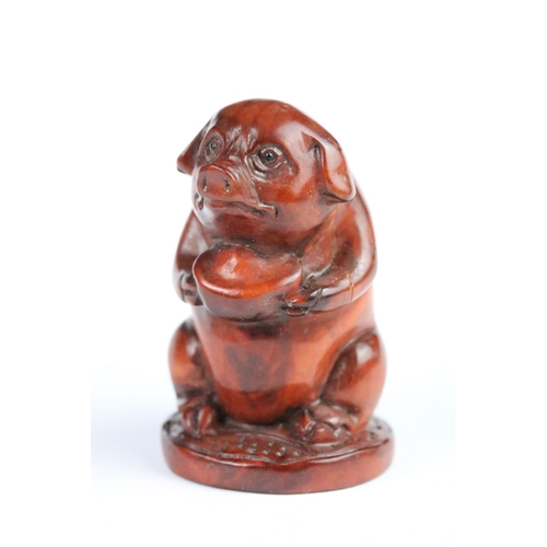 283 - Two carved wooden netsuke to include a pig and a fu dog. Measures 5cm and 6cm.