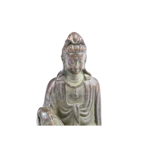 297 - Cast bronze Guanyin Buddha figurine modelled seated on a bench. Measures 8.5cm tall.