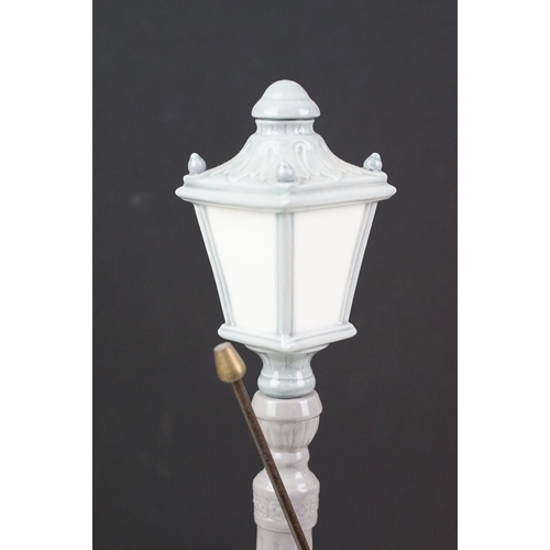 56 - Lladro ceramic figurine in the form of a Victorian lamp lighter complete in original box. Measures 4... 