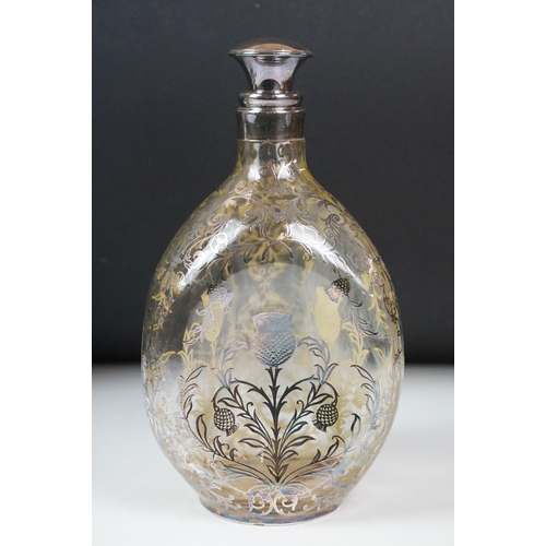 6 - Set of three glass decanters of pinched form, the decanters with white metal overlay in the form of ... 