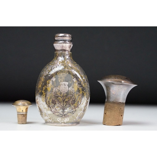 6 - Set of three glass decanters of pinched form, the decanters with white metal overlay in the form of ... 