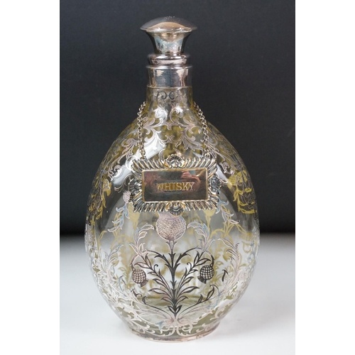 6 - Set of three glass decanters of pinched form, the decanters with white metal overlay in the form of ... 