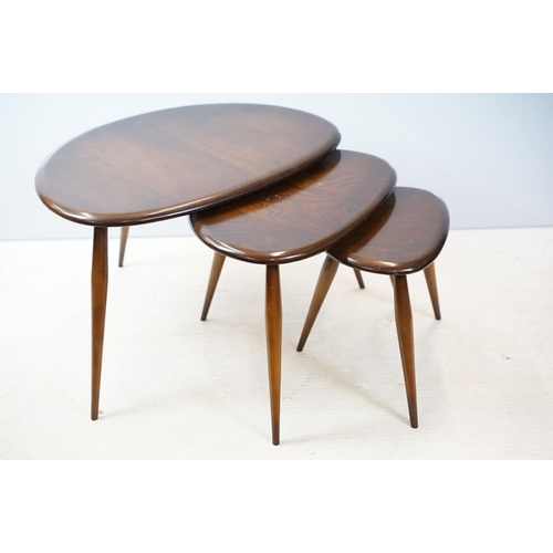 648 - Ercol nest of three dark elm pebble tables (lacking maker's labels), largest table 41cm high x 65cm ... 