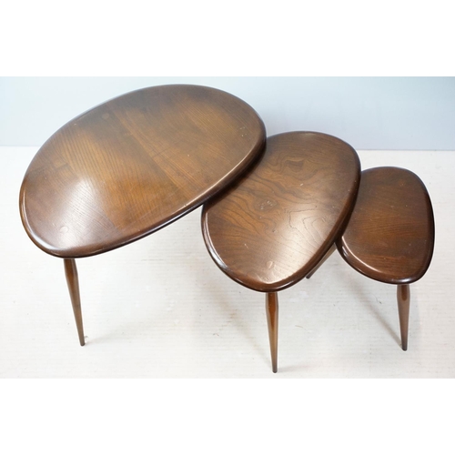 648 - Ercol nest of three dark elm pebble tables (lacking maker's labels), largest table 41cm high x 65cm ... 