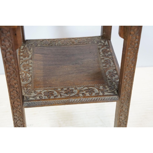 661 - Eastern style two tier occasional table, the florally carved top with 9 x 9 game board, 53cm high x ... 