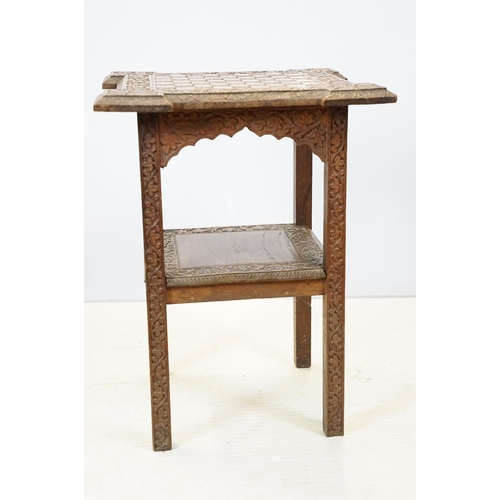 661 - Eastern style two tier occasional table, the florally carved top with 9 x 9 game board, 53cm high x ... 