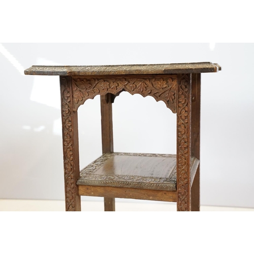 661 - Eastern style two tier occasional table, the florally carved top with 9 x 9 game board, 53cm high x ... 