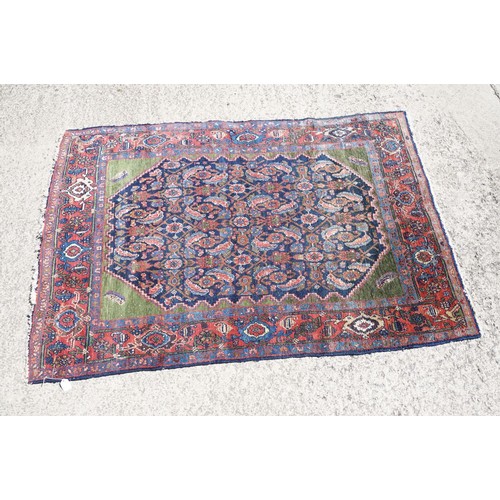 693 - Middle Eastern carpet rug having a large blue medallion to centre within a red border. Measures 183 ... 