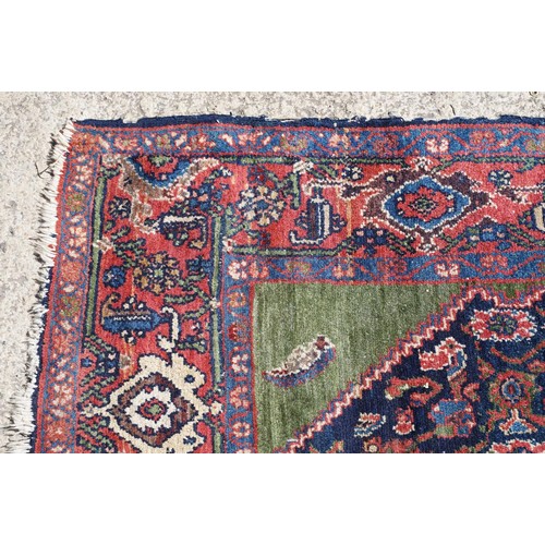 693 - Middle Eastern carpet rug having a large blue medallion to centre within a red border. Measures 183 ... 