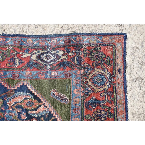 693 - Middle Eastern carpet rug having a large blue medallion to centre within a red border. Measures 183 ... 