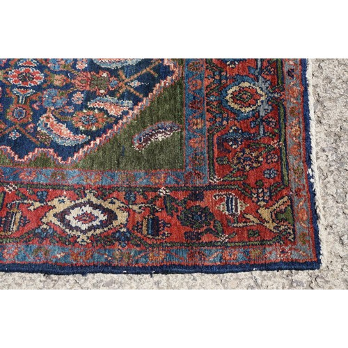 693 - Middle Eastern carpet rug having a large blue medallion to centre within a red border. Measures 183 ... 