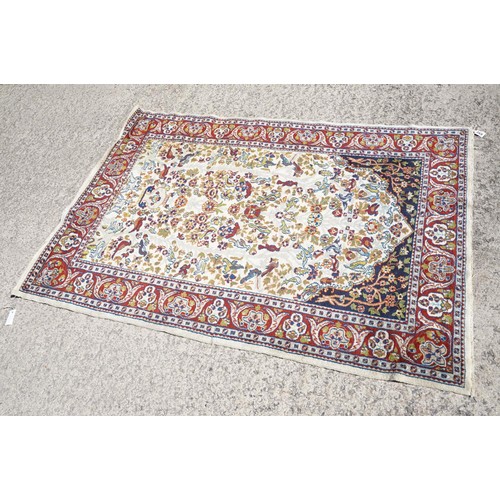 692 - Middle Eastern carpet rug having a white arched panel to centre decorated with florals and fauna wit... 